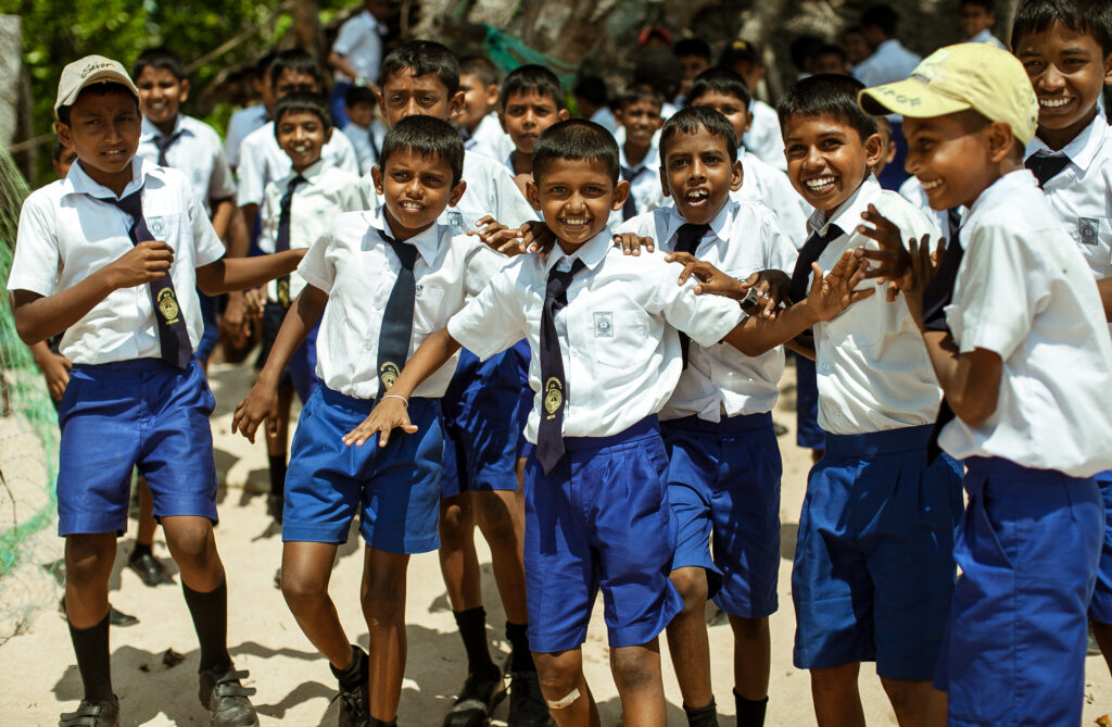school children dressed in uniform have fun and play in the schoolyard. wadduwa, sri lanka.