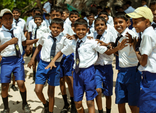 school children dressed in uniform have fun and play in the schoolyard. wadduwa, sri lanka.